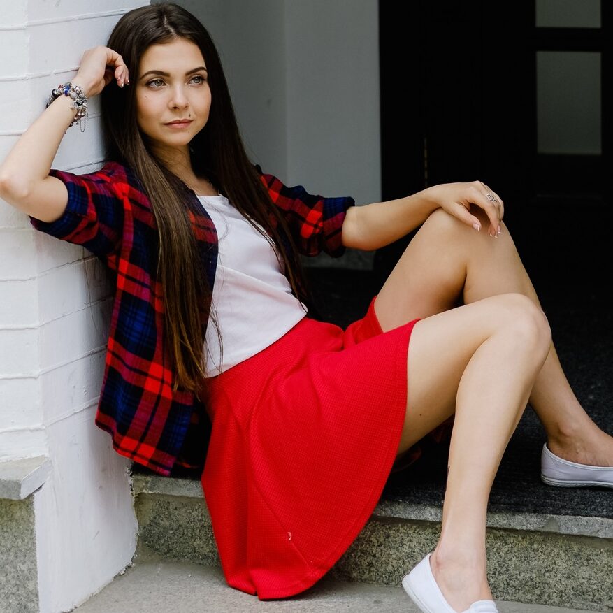 woman in skirt sitting on street