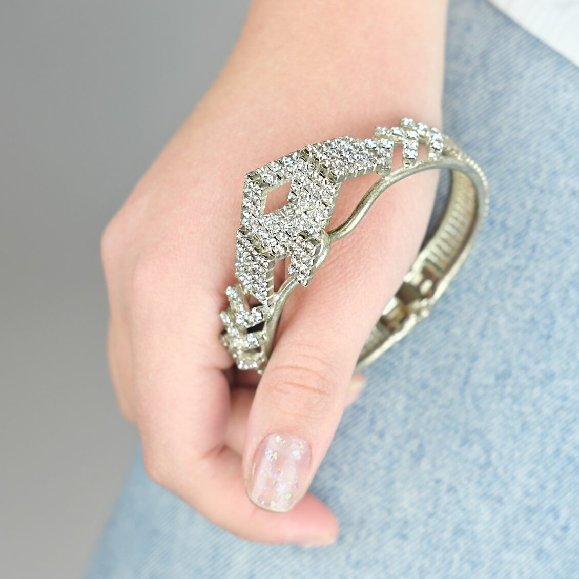 young woman holding shining bracelet with artifical gems.